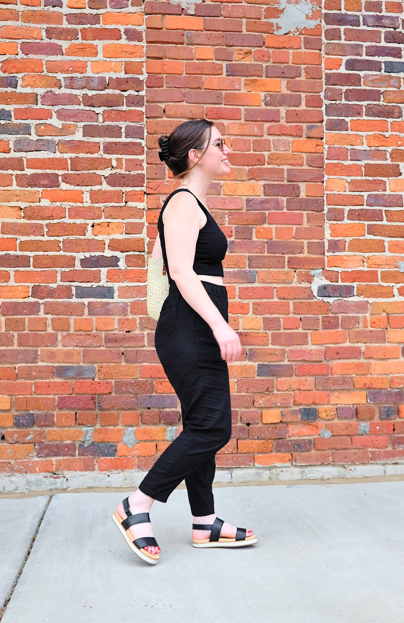 Alyssa walks on a sidewalk while wearing the Flatform sandals