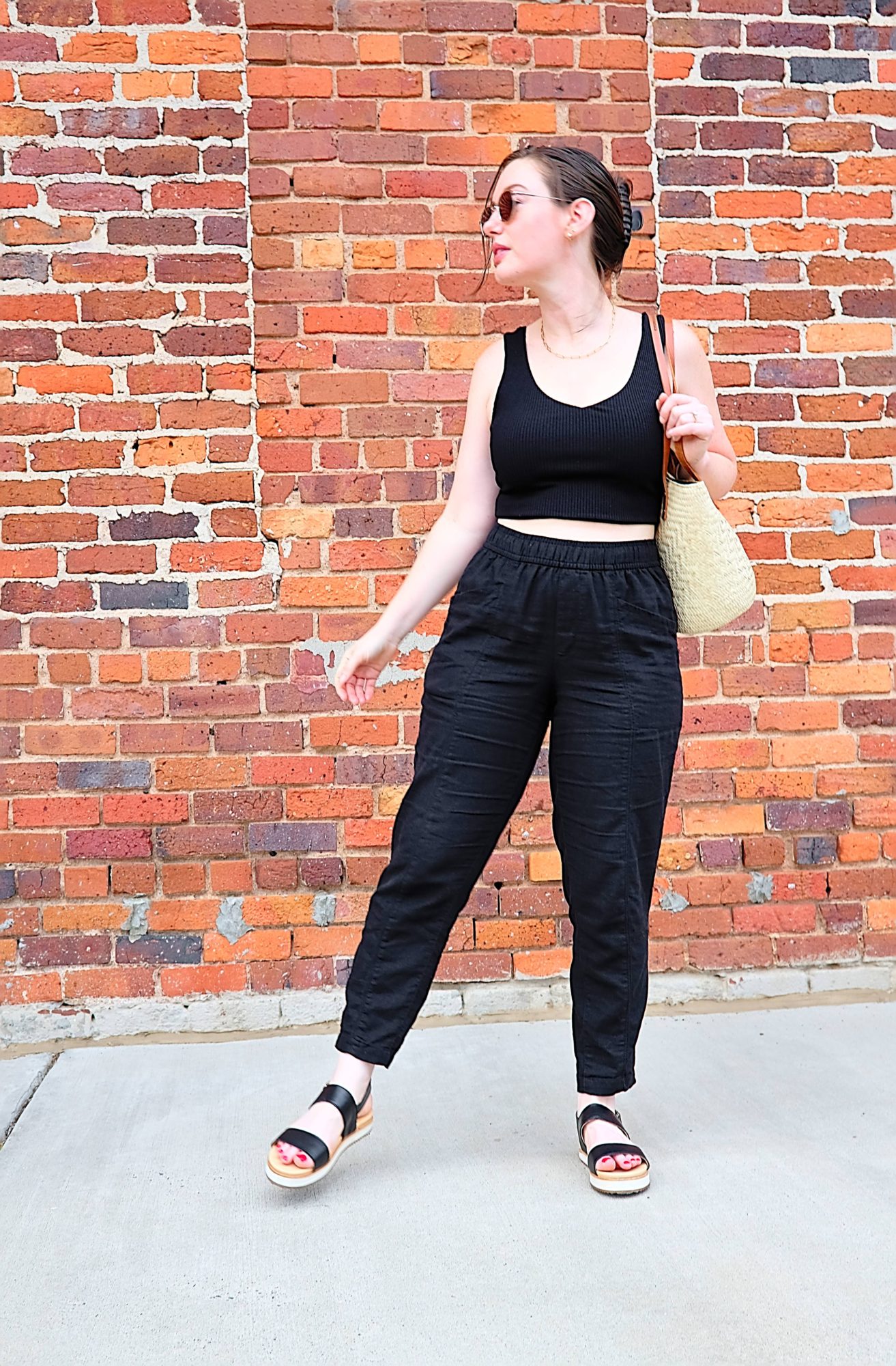 Alyssa wears a crop top, linen pants, and the Nisolo sandals while moving