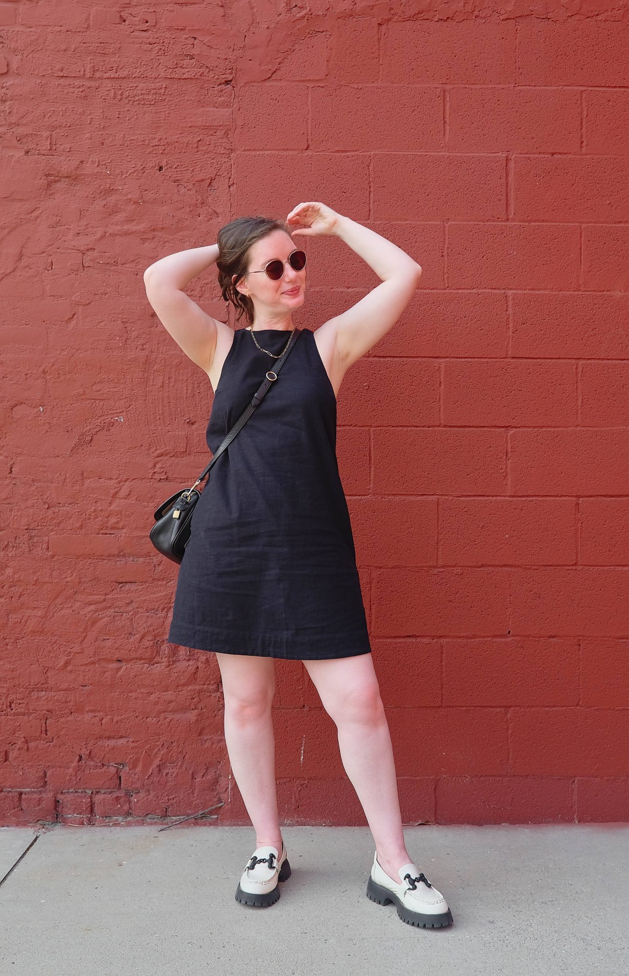 Alyssa wears a black linen dress with white loafers