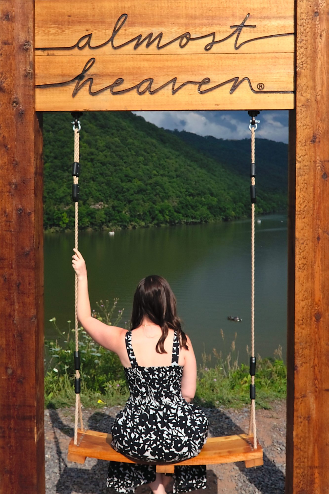Alyssa sits on the Almost Heaven swing, facing away from the camera