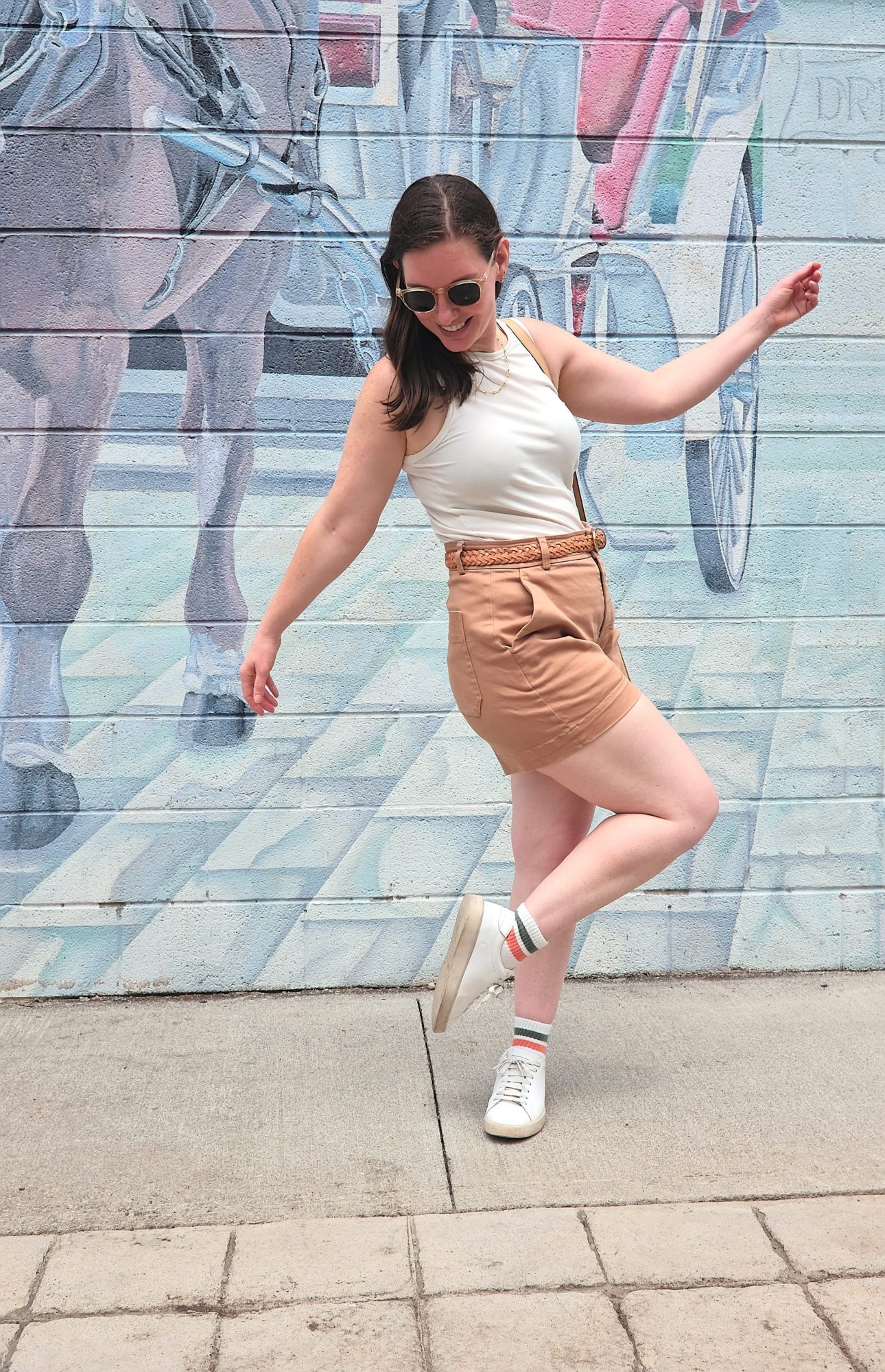Alyssa strikes a pose in a white tank and brown shorts
