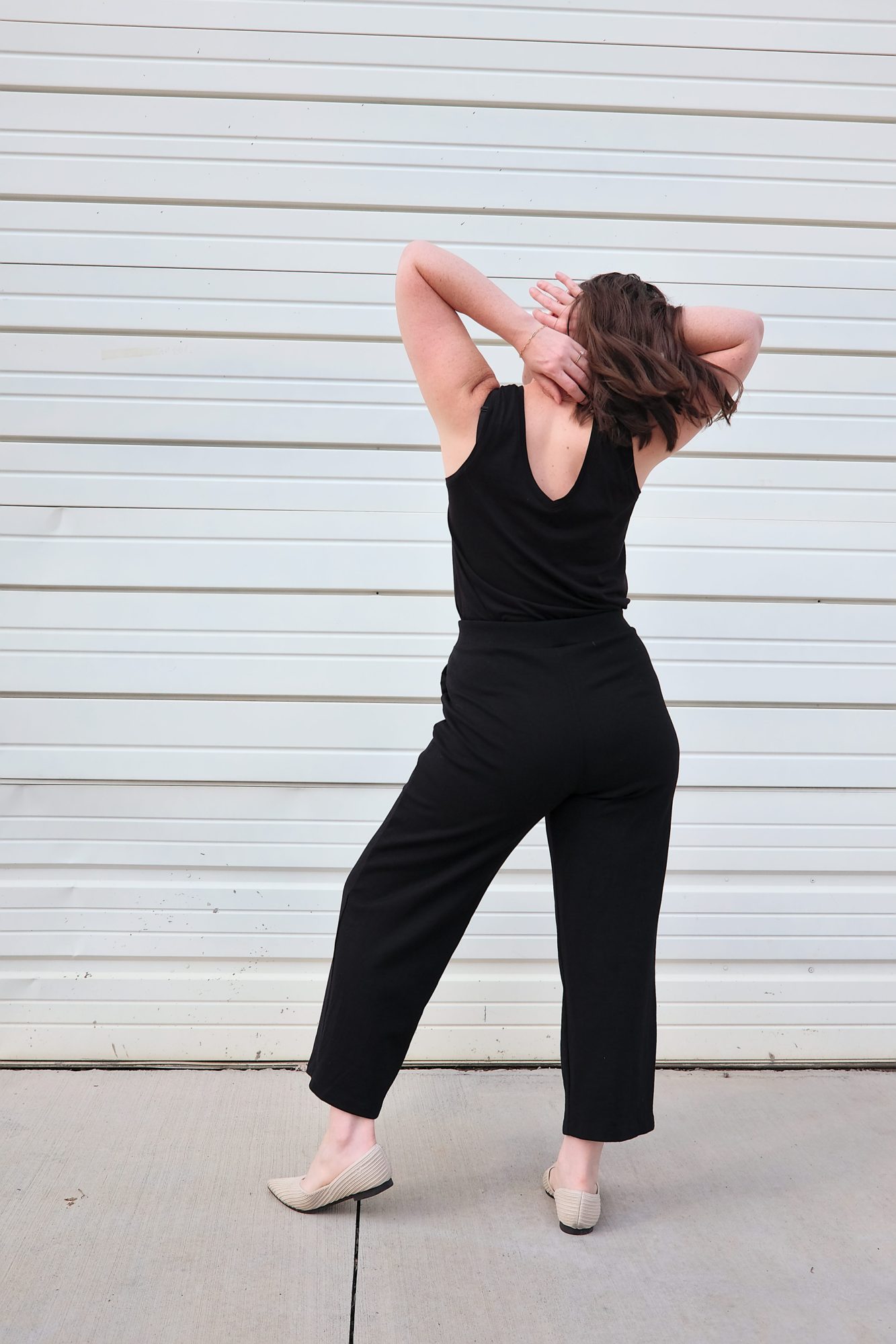 Alyssa turns away from the camera, revealing the V-back of the Poppy Tank