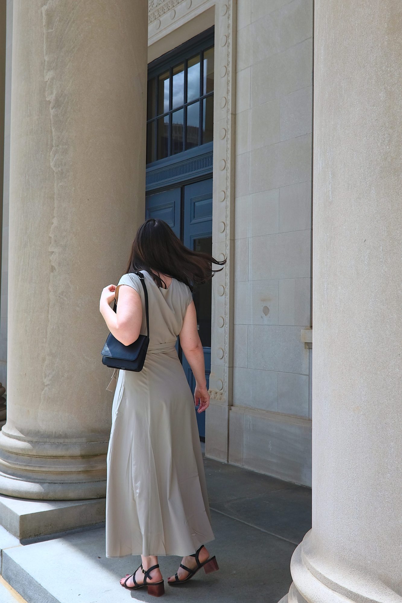 Alyssa wears a grey dress and faces away from the camera