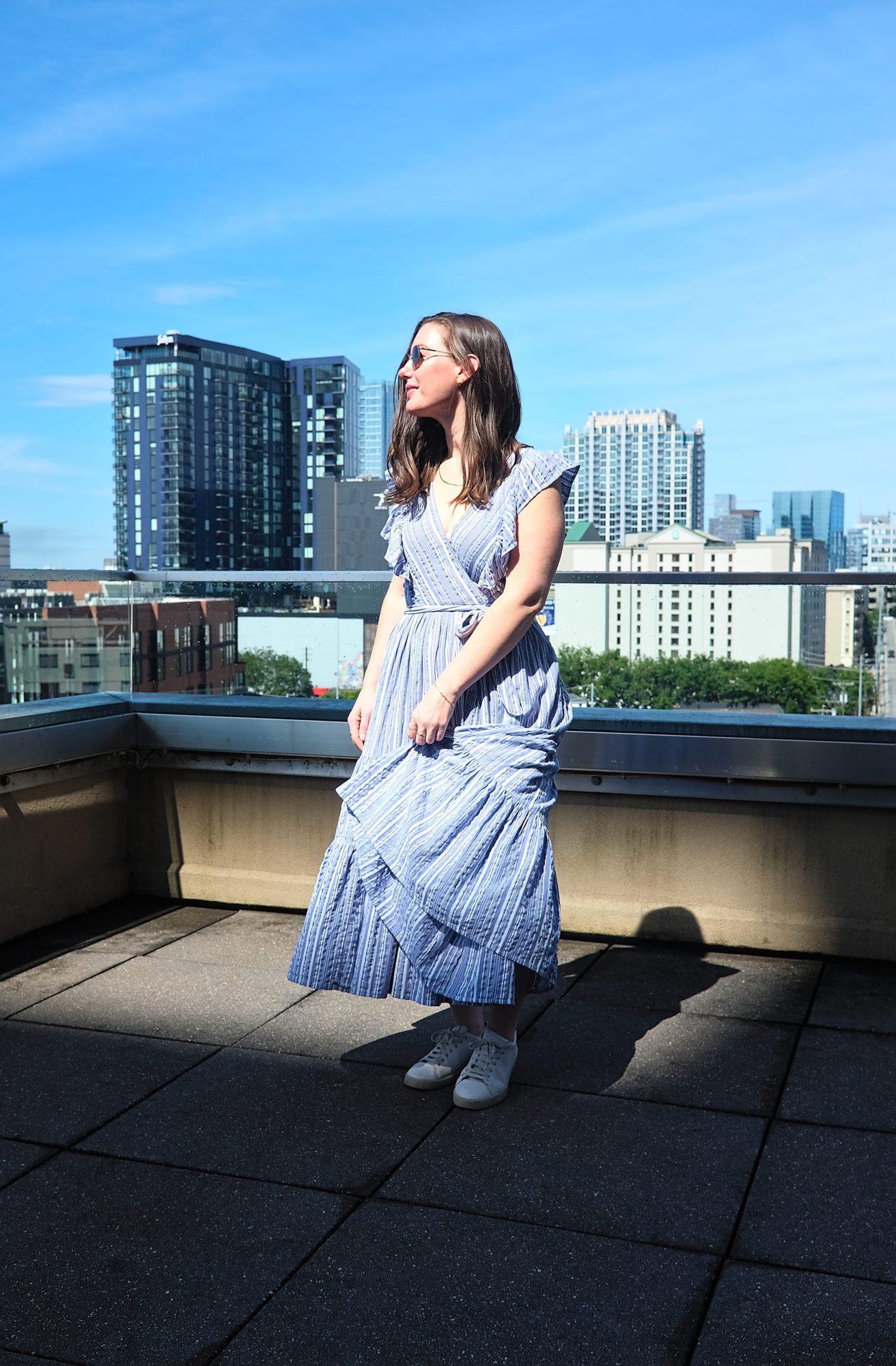 Alyssa wears a blue dress with sneakers on a roof in Nashville