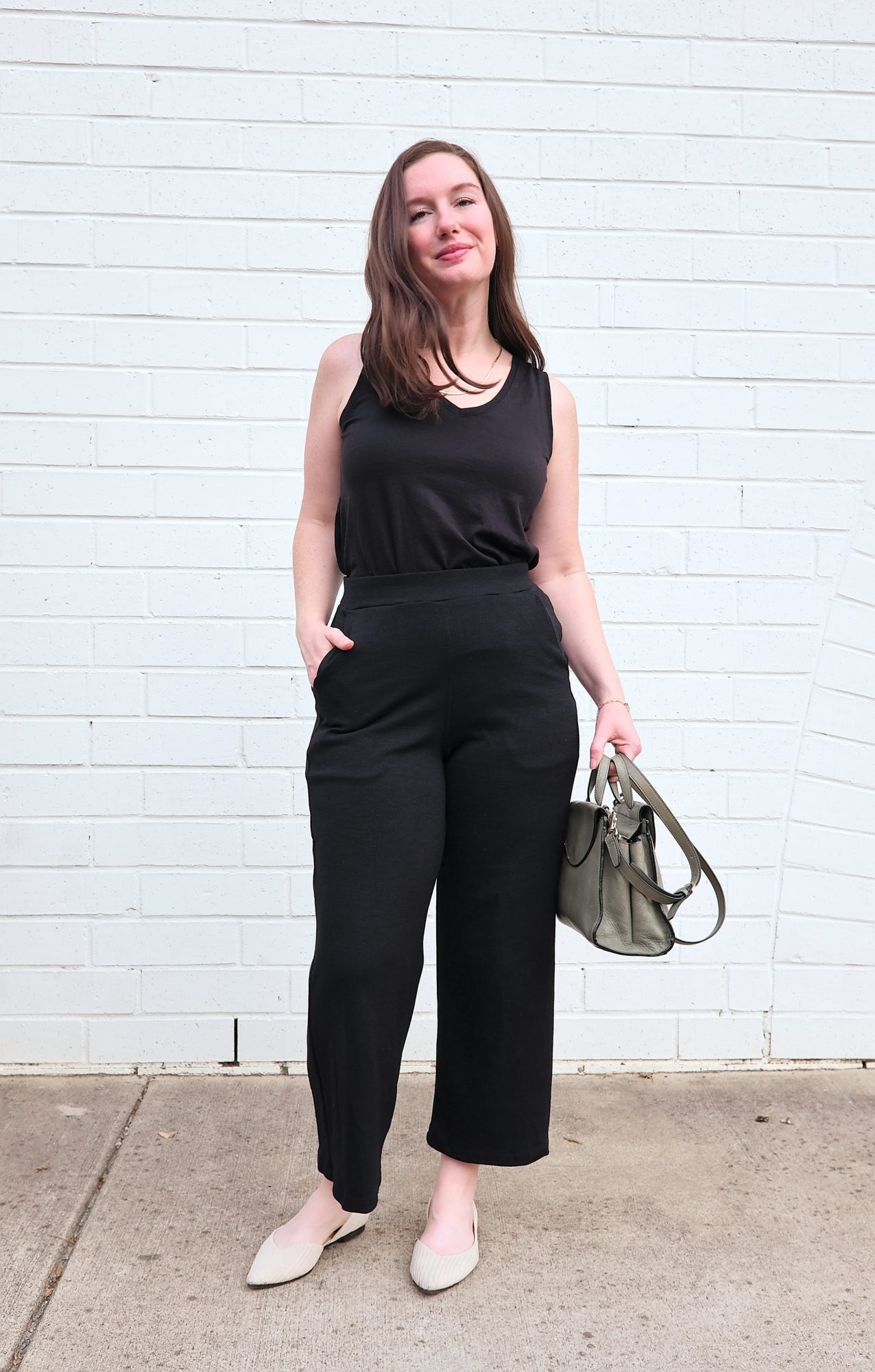 Alyssa wears the Poppy Tank with the Frame Ponte Culottes and carries a green bag