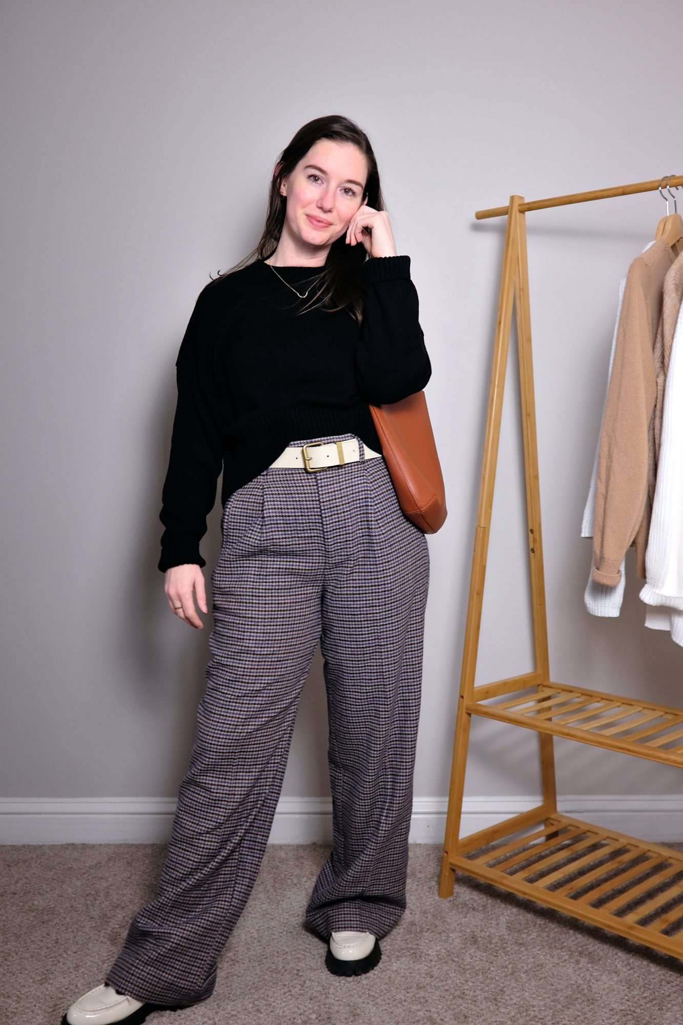 Alyssa wears a black sweater with plaid wool pants and white loafers with the Everlane bag
