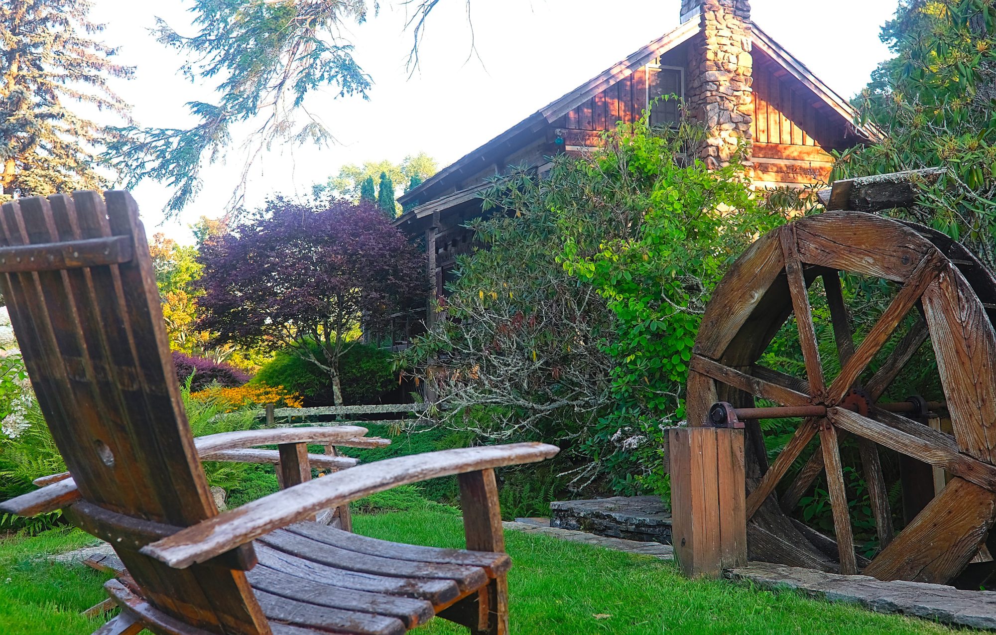 Exterior of the log cabin with a water wheel