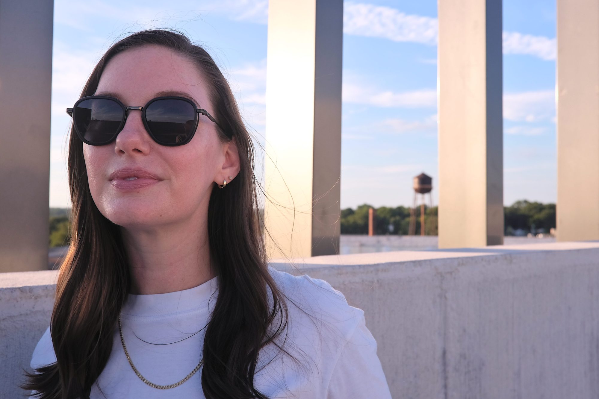 Alyssa wears the Bernina sunglasses in front of a water tower