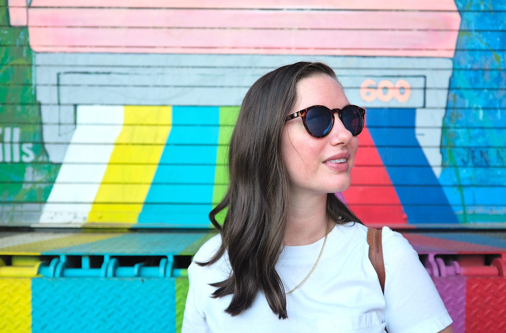 Alyssa turns in profile to the camera while wearing a pair of Sunski sunglasses under review