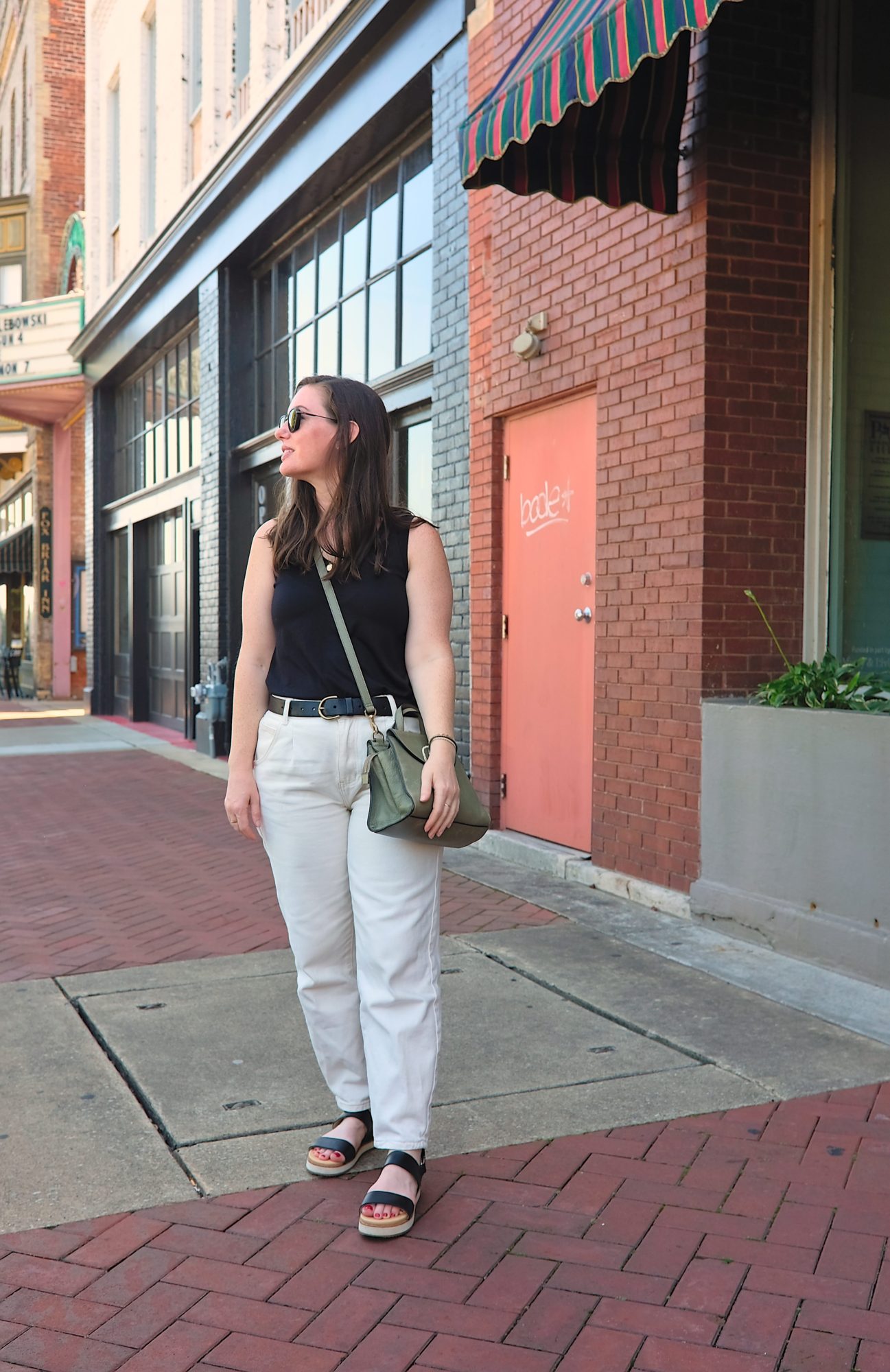 Alyssa wears a black tank with white denim