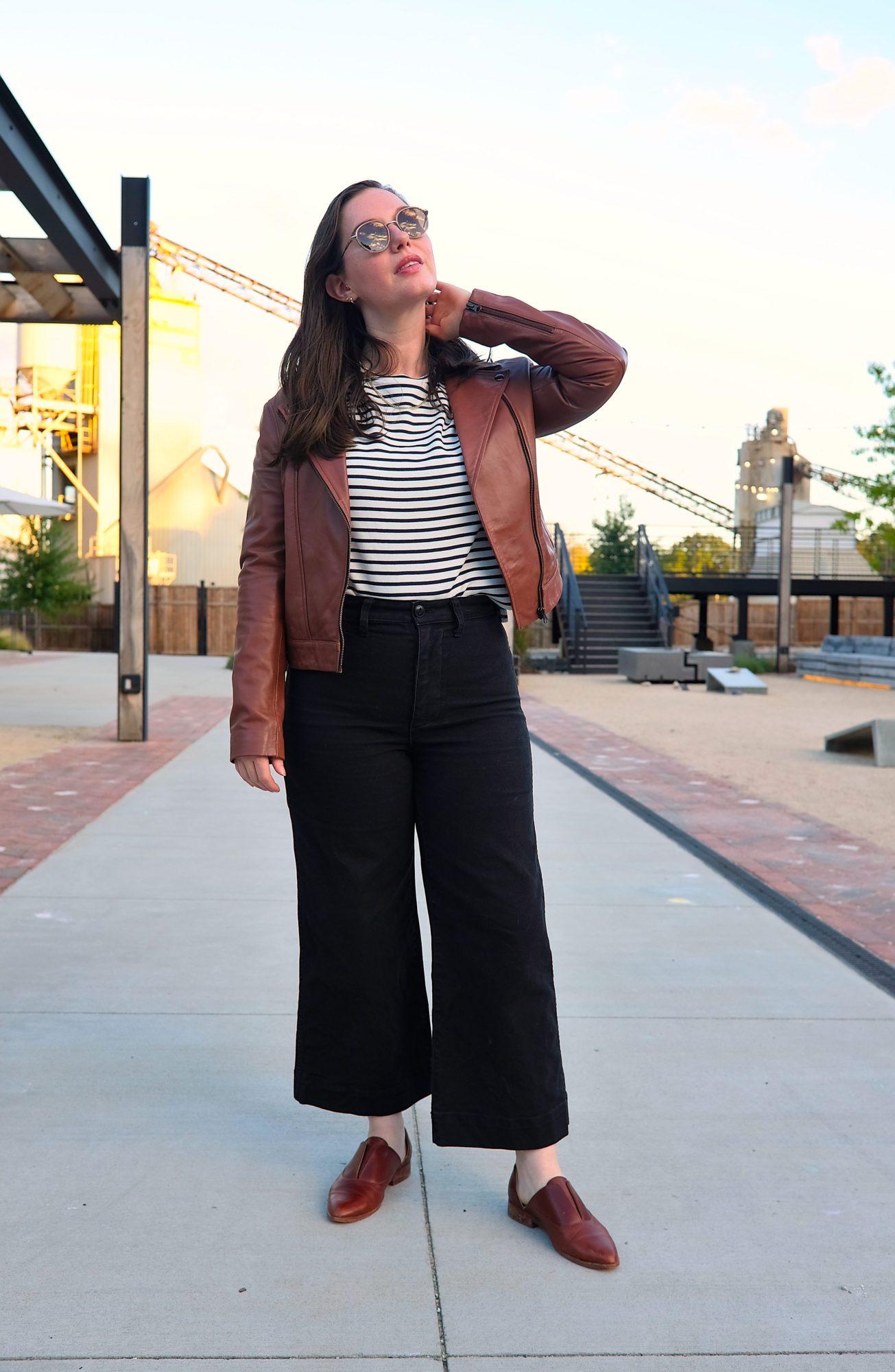 Alyssa wears the Maha Leather Jacket from ABLE with a striped tee and wide-leg pants