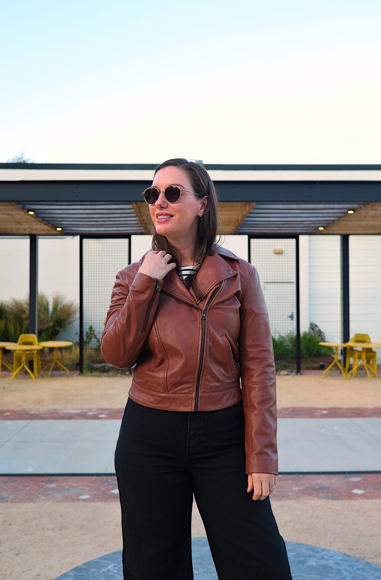 Alyssa wears the ABLE leather jacket zipped