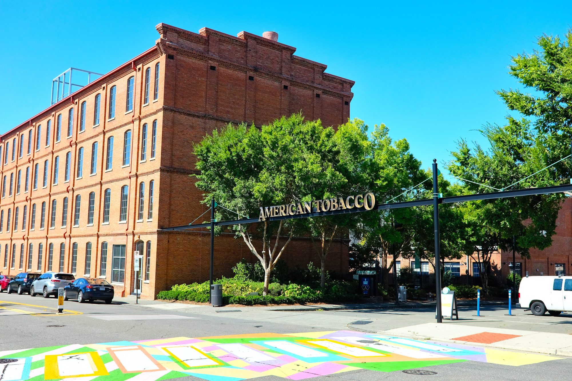 A sign reads "American Tobacco" with brick buildings in the background