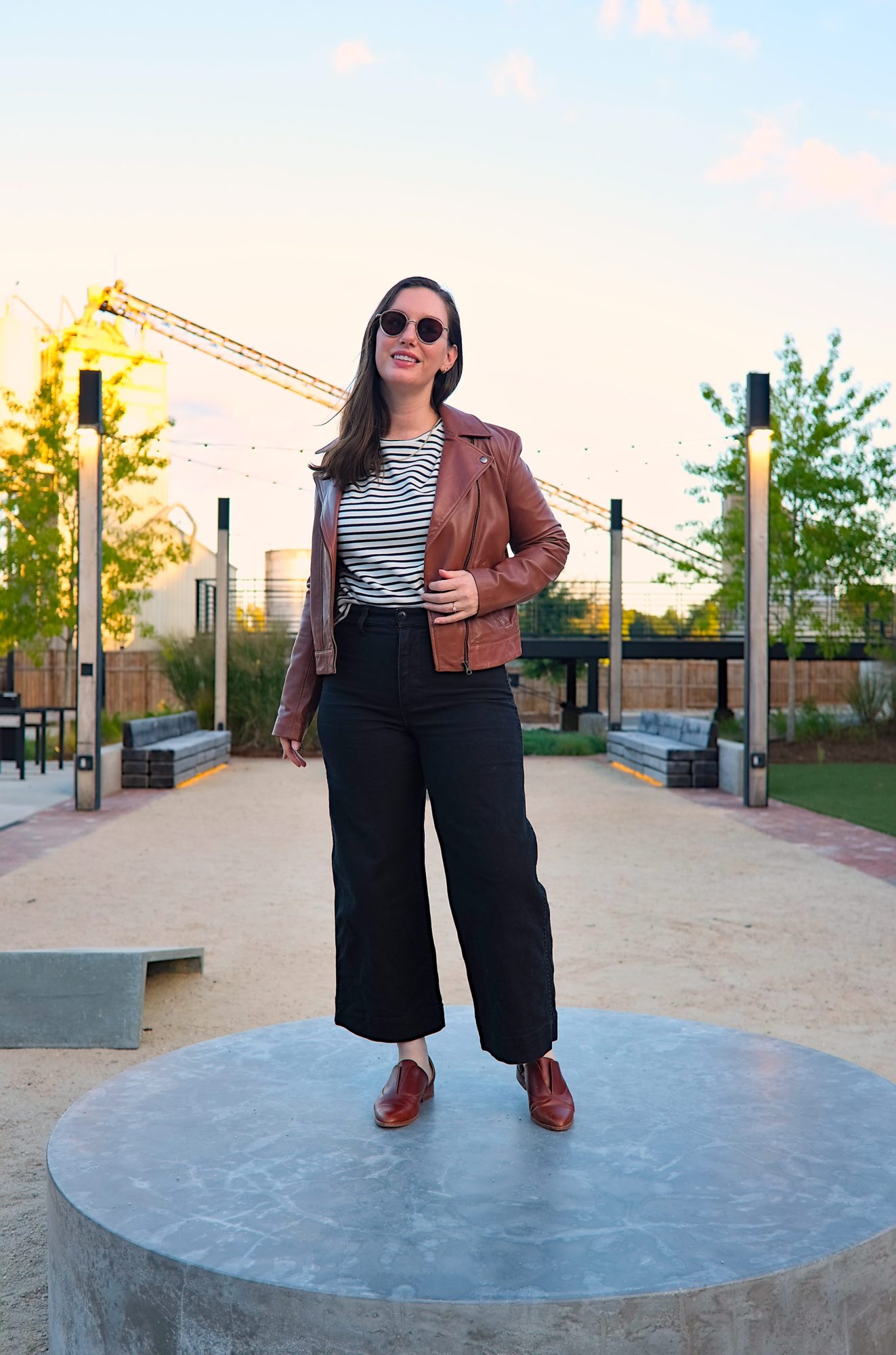 Alyssa wears the Maha leather jacket with a striped tee and black pants