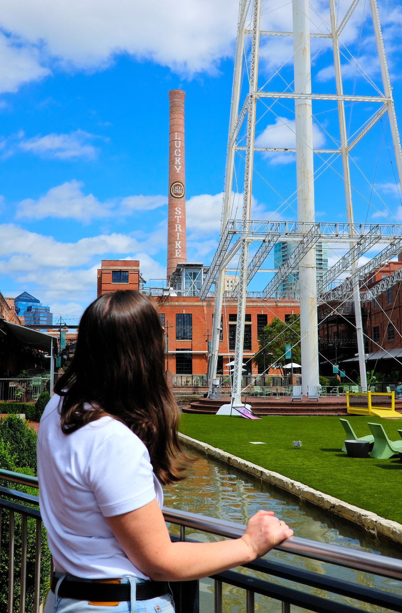 Alyssa looks at the Lucky Strike water tower, wearing a white tee