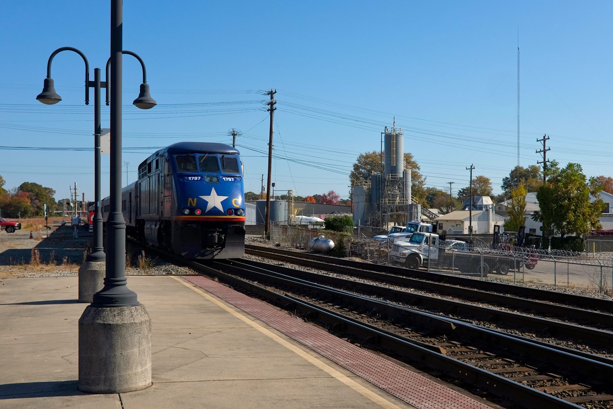 A train pulls away from the station, it is emblazoned with NC