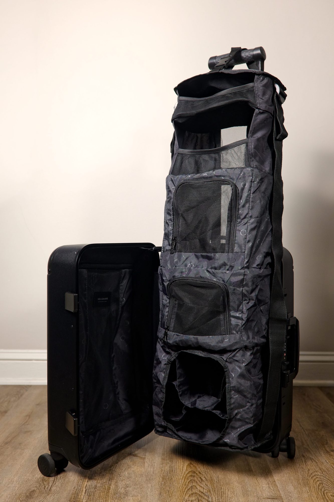 A suitcase with a built-in closet hanging from the handle