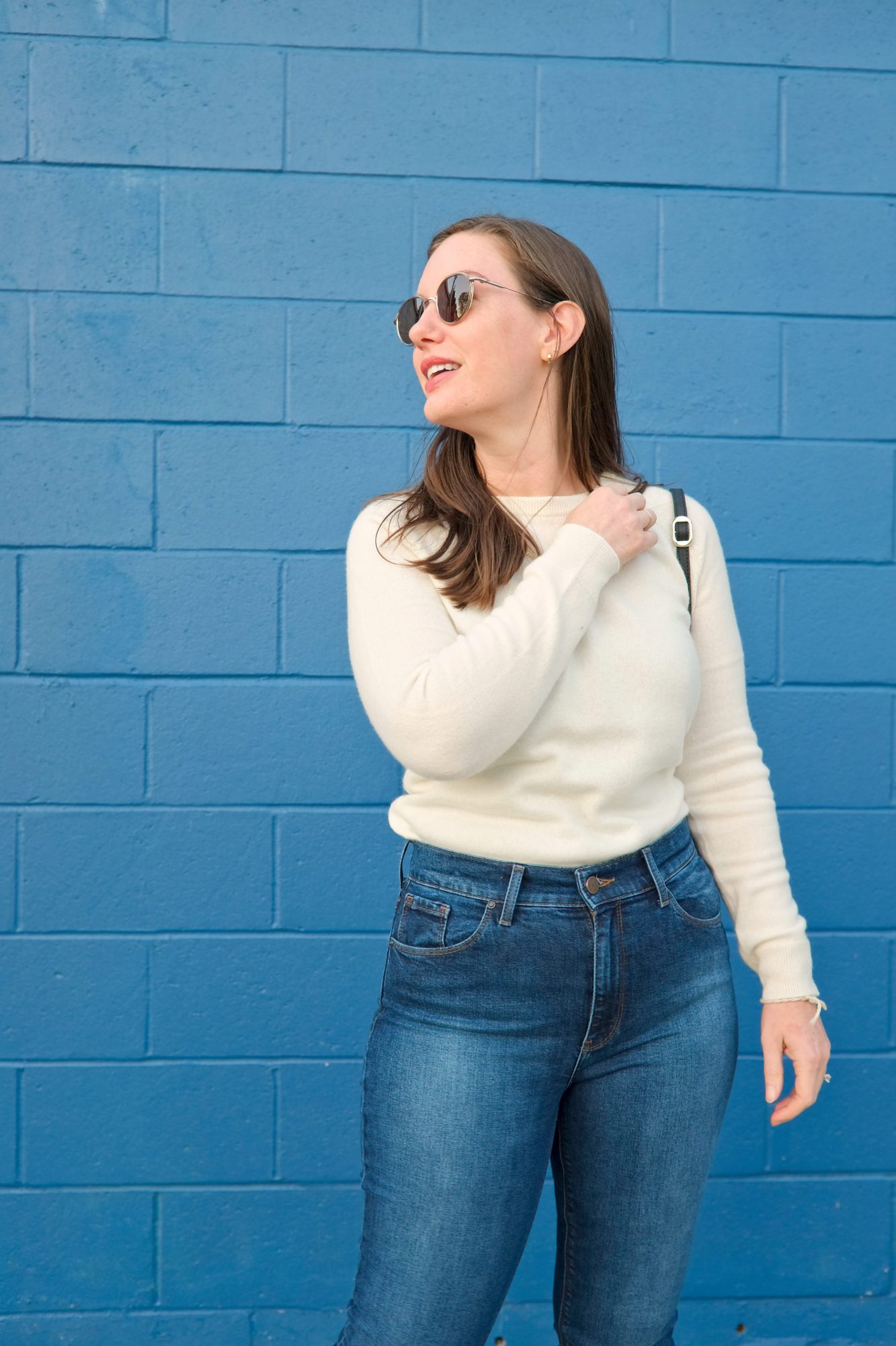 Alyssa wears a white sweater from Mott & Bow