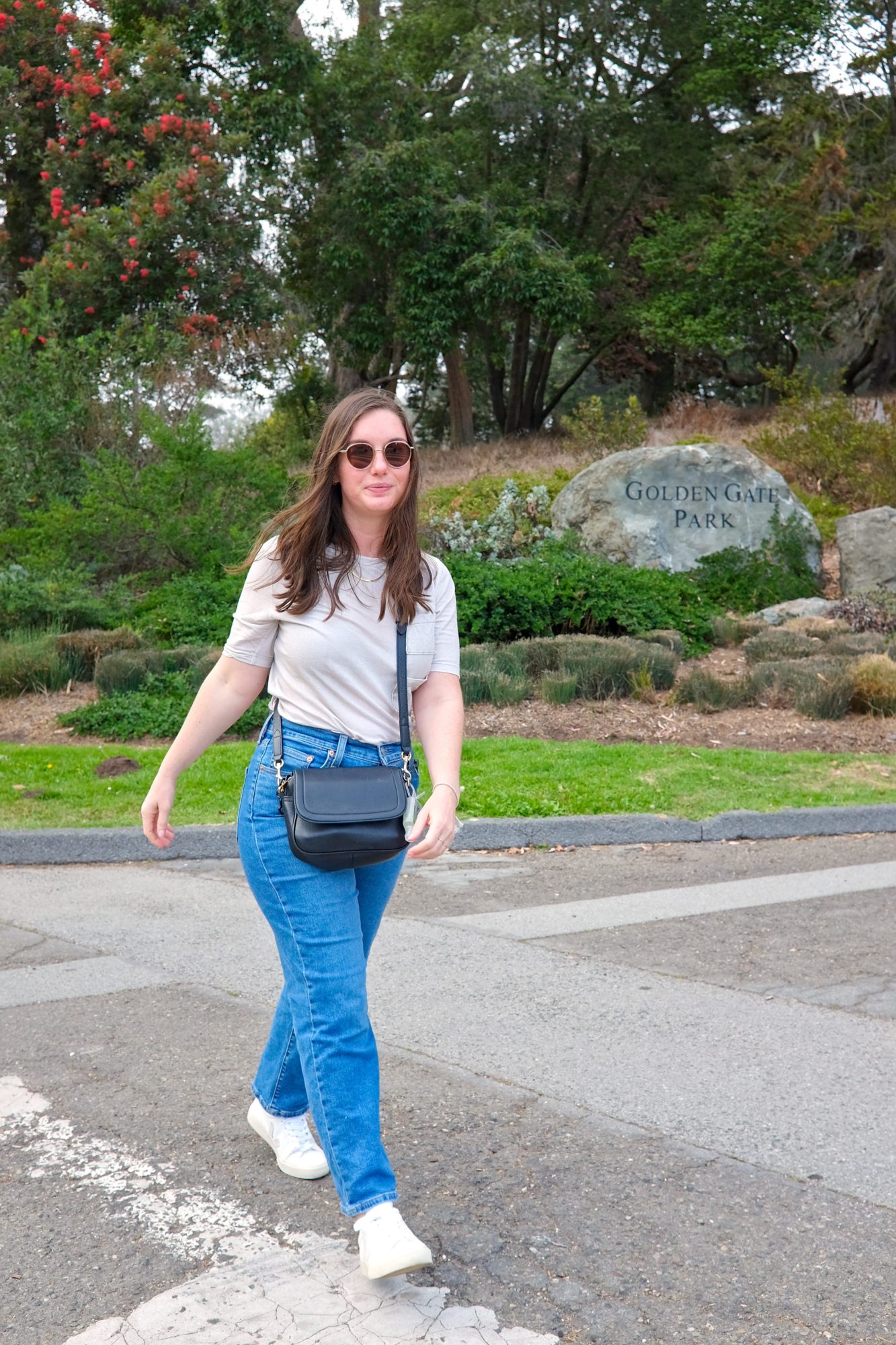 Alyssa wears an off-white tee with blue jeans in Golden Gate Park
