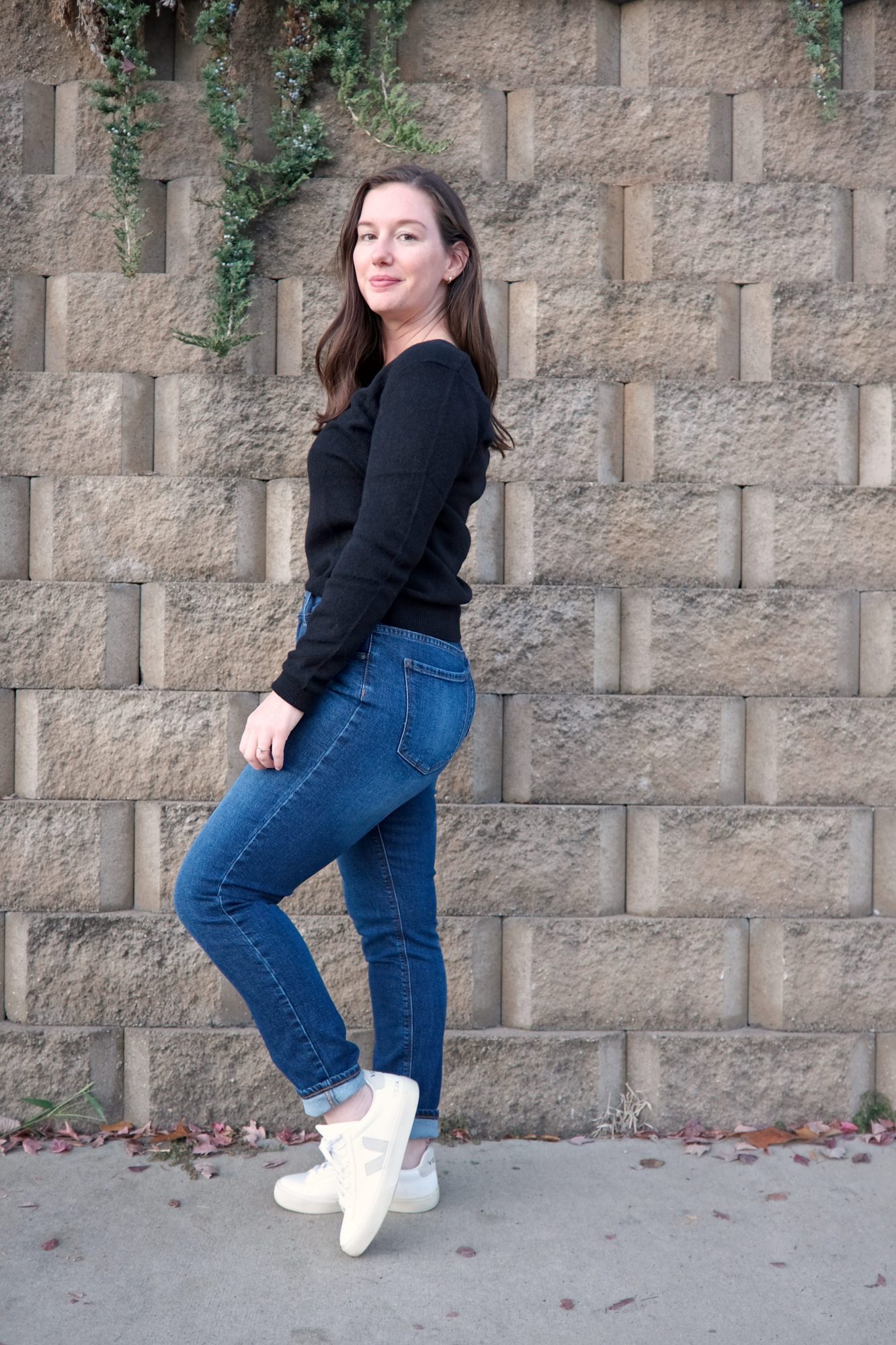 Alyssa wears a black sweater and turns in profile to the camera