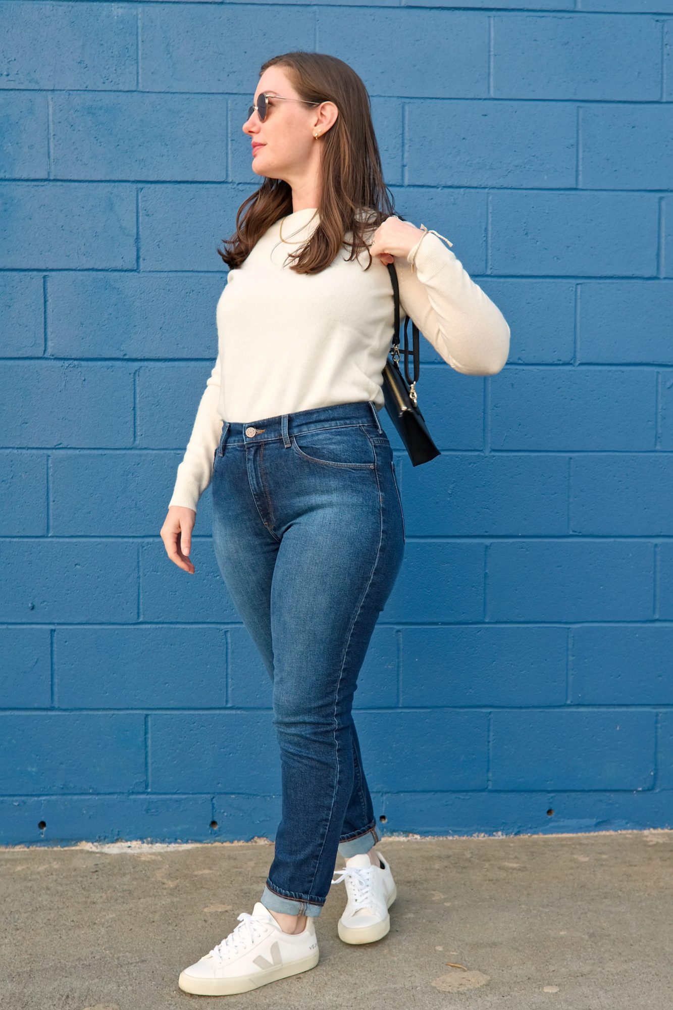 Alyssa wears the cream sweater from Mott & Bow and turns at an angle
