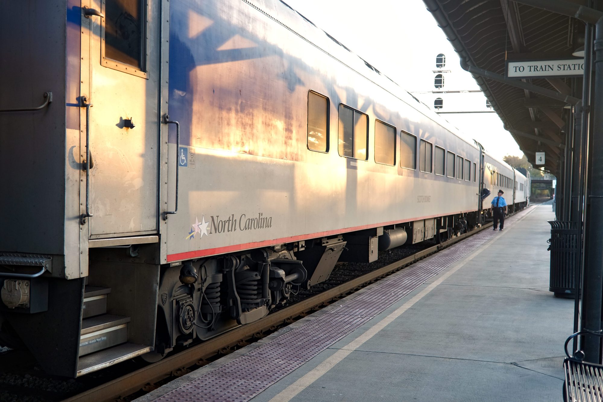 A passenger exits the train with a suitcase