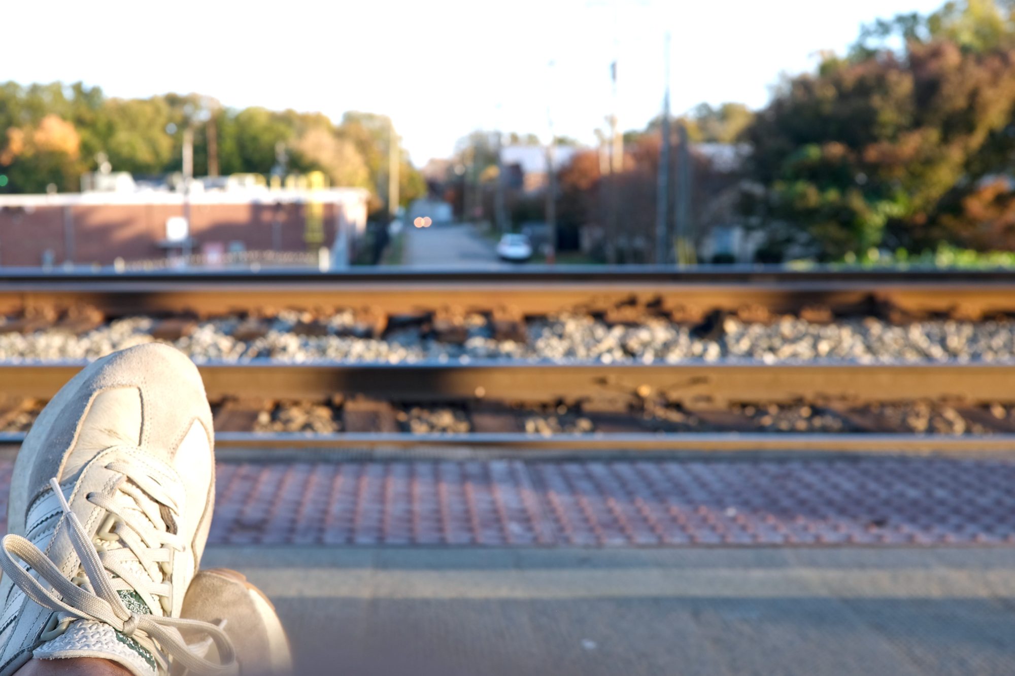 Michael's feet are shown in the foreground as he waits for the train