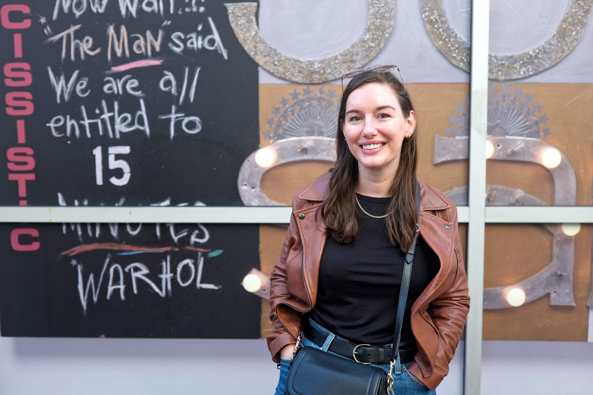 Alyssa wears a black top with a brown leather jacket