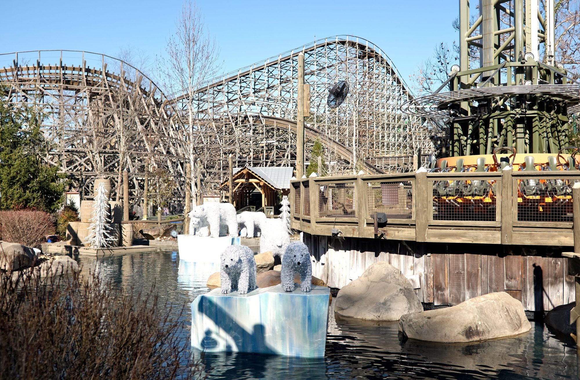 A rollercoaster in the background with floating polar bear sculptures on "ice"