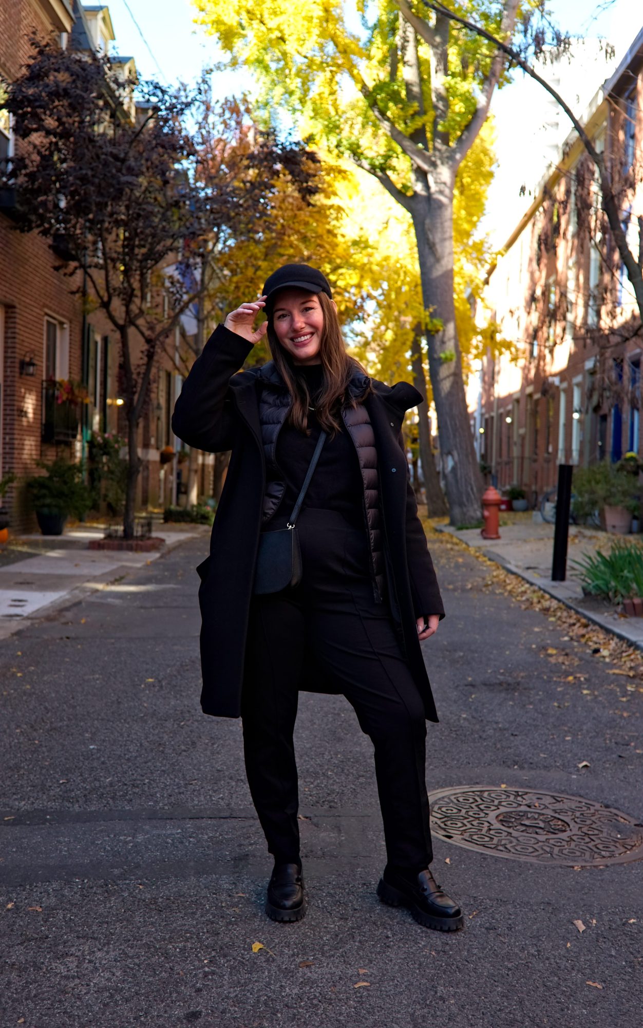 Alyssa wears an all black outfit with wool pants, a cashmere sweater, wool coat, and cashmere cap