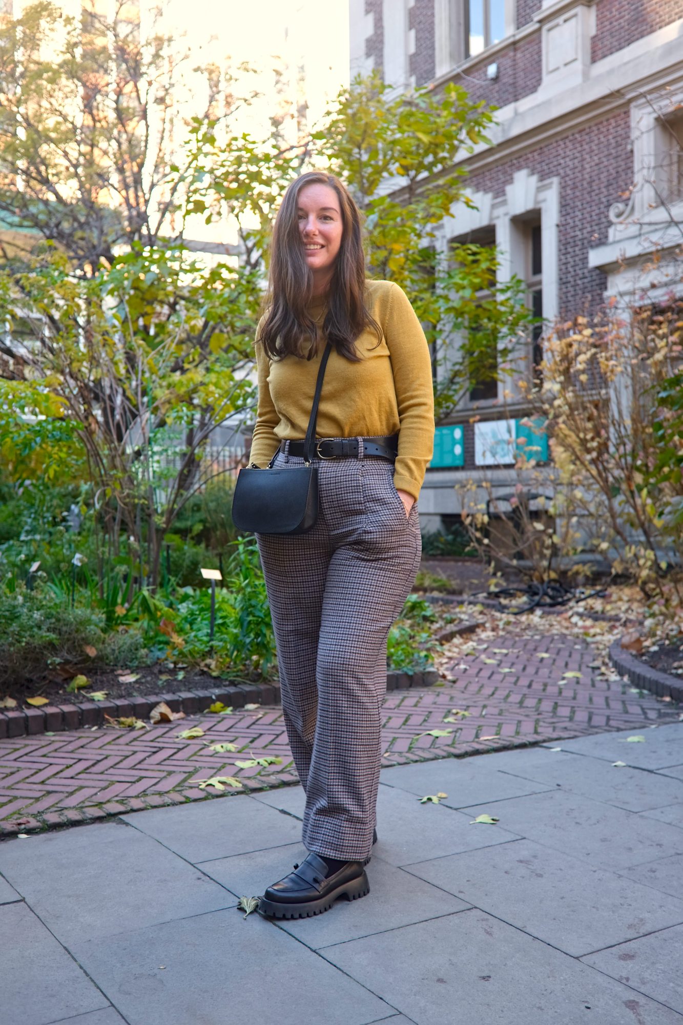 Alyssa wears a mustard sweater with houndstooth wool pants and chunky loafers 