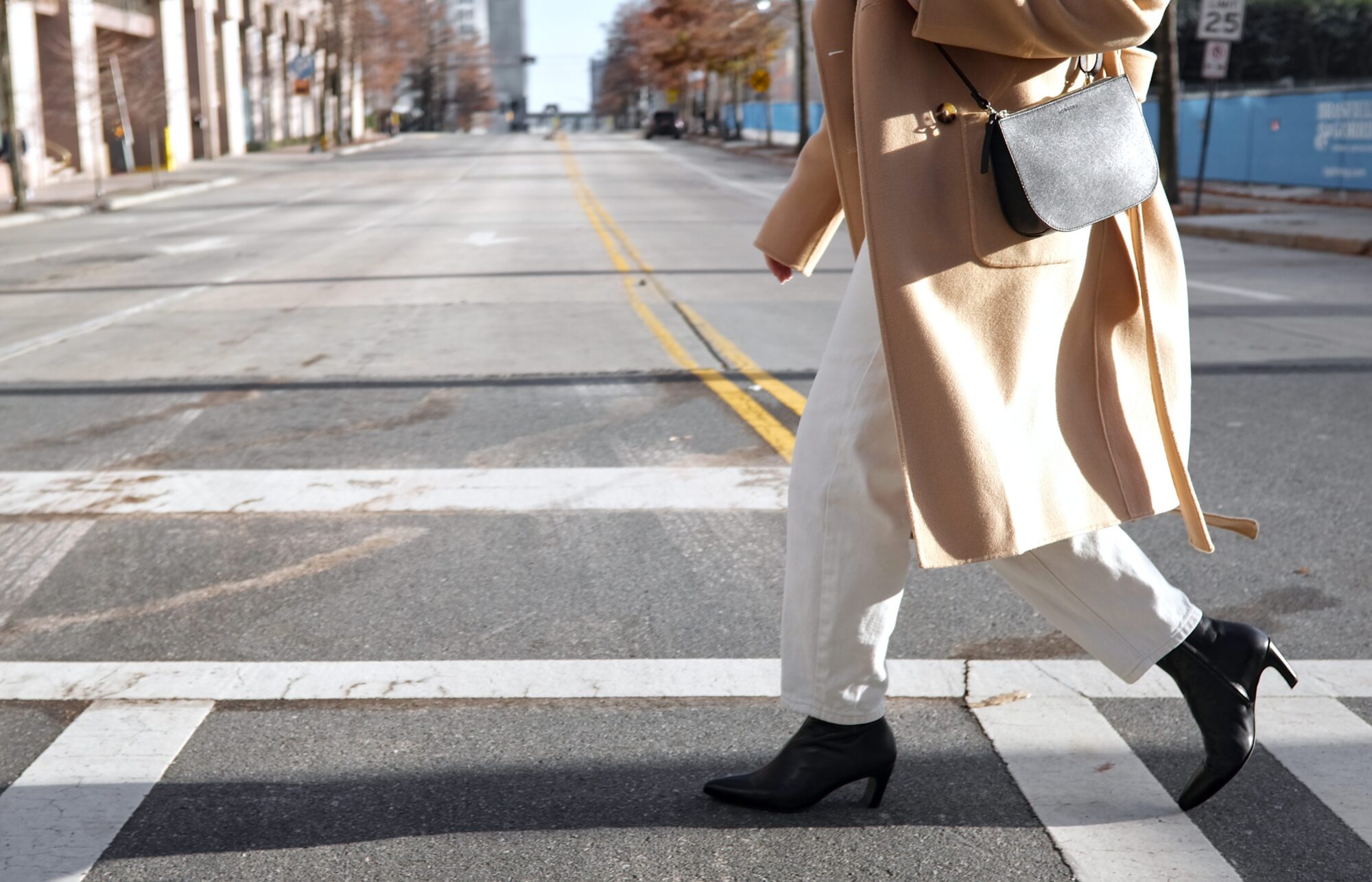 Alyssa crosses the street in a pair of Poppy Barley boots