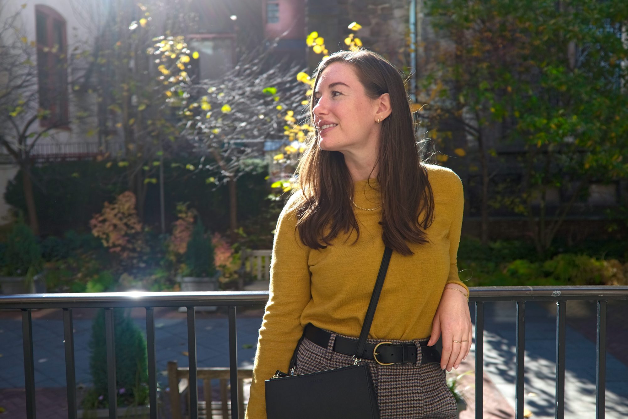 Alyssa wears a mustard sweater with houndstooth pants