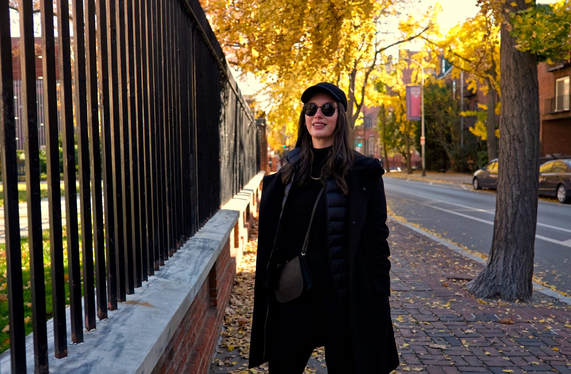 Alyssa wears an all black outfit on a sidewalk in Philadelphia