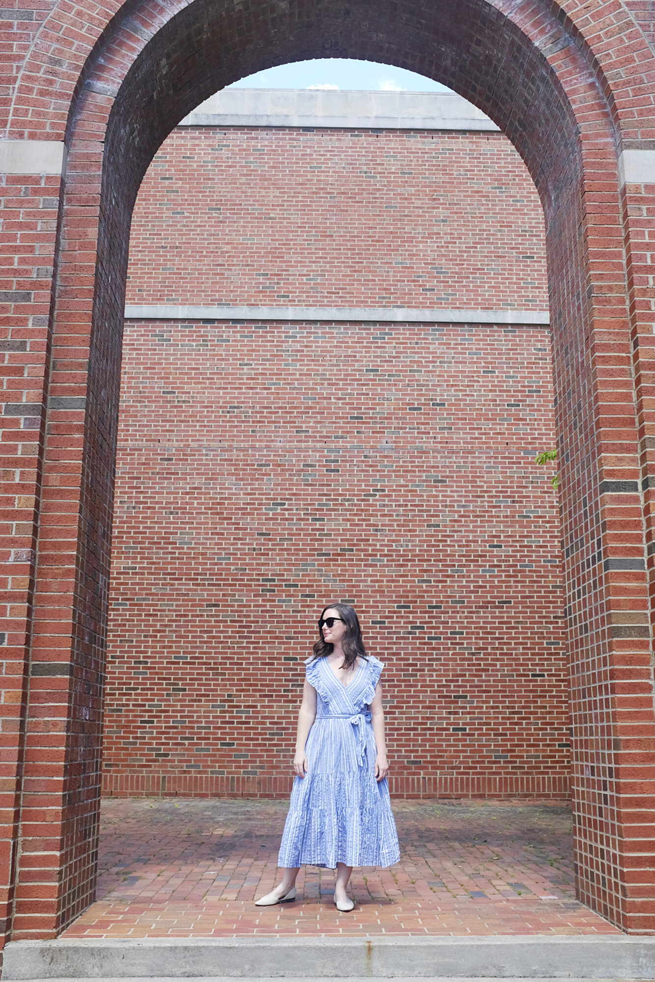 Alyssa stands under a large brick arch in Chapel Hill