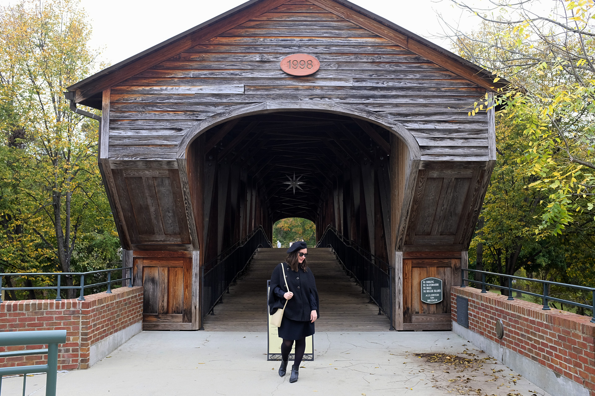 Alyssa stands in front of the bridge in Old Salem