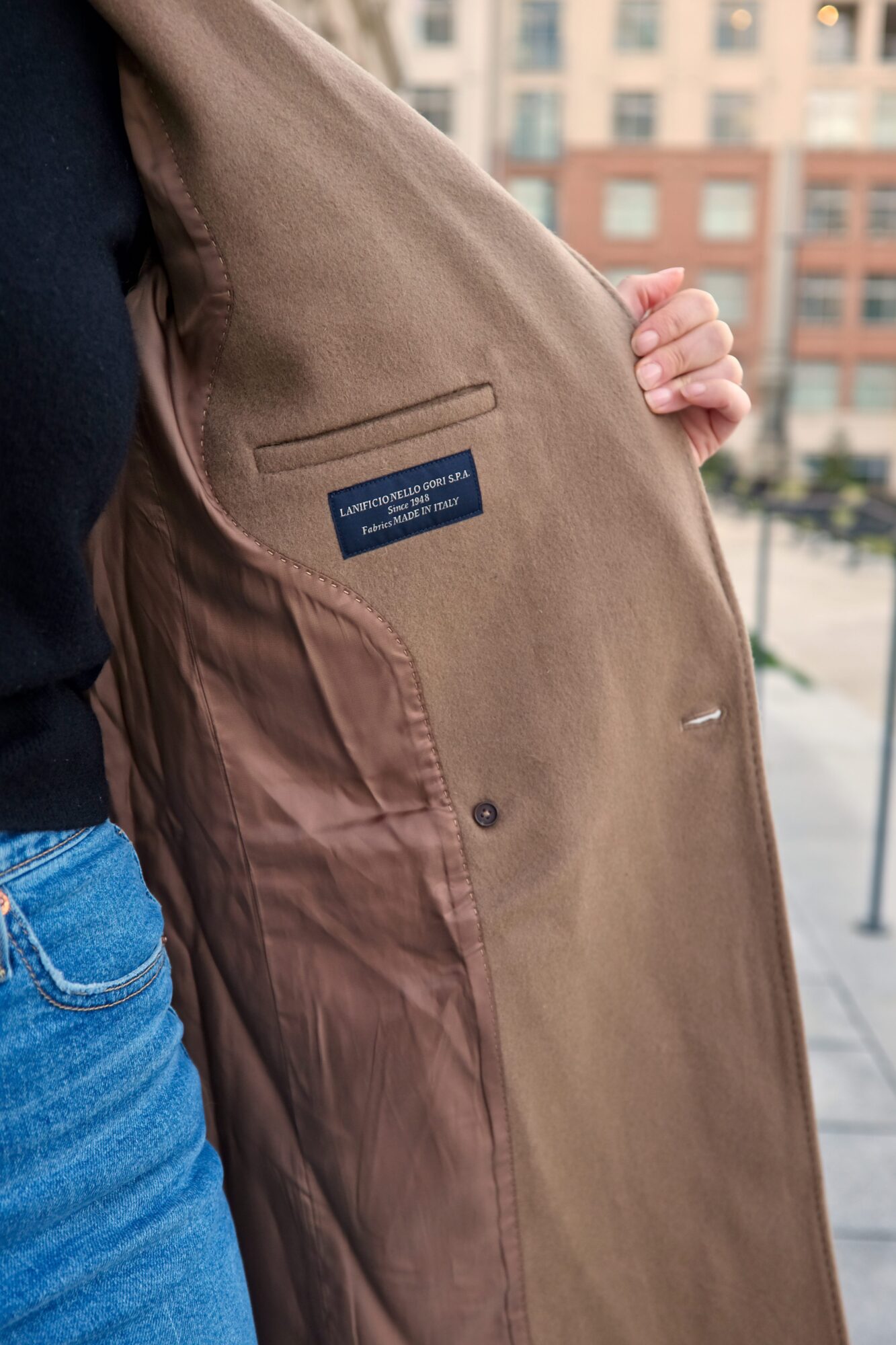 Alyssa shows the interior of the coat with a label indicating the fabric is from Italy