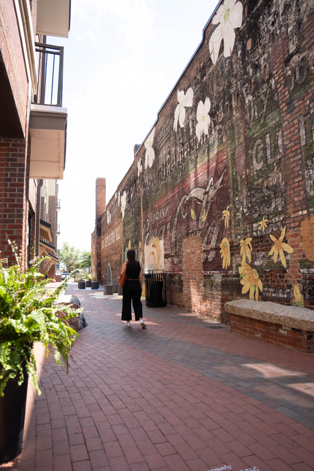 Alyssa walks through an alley with murals in Rock Hill, SC