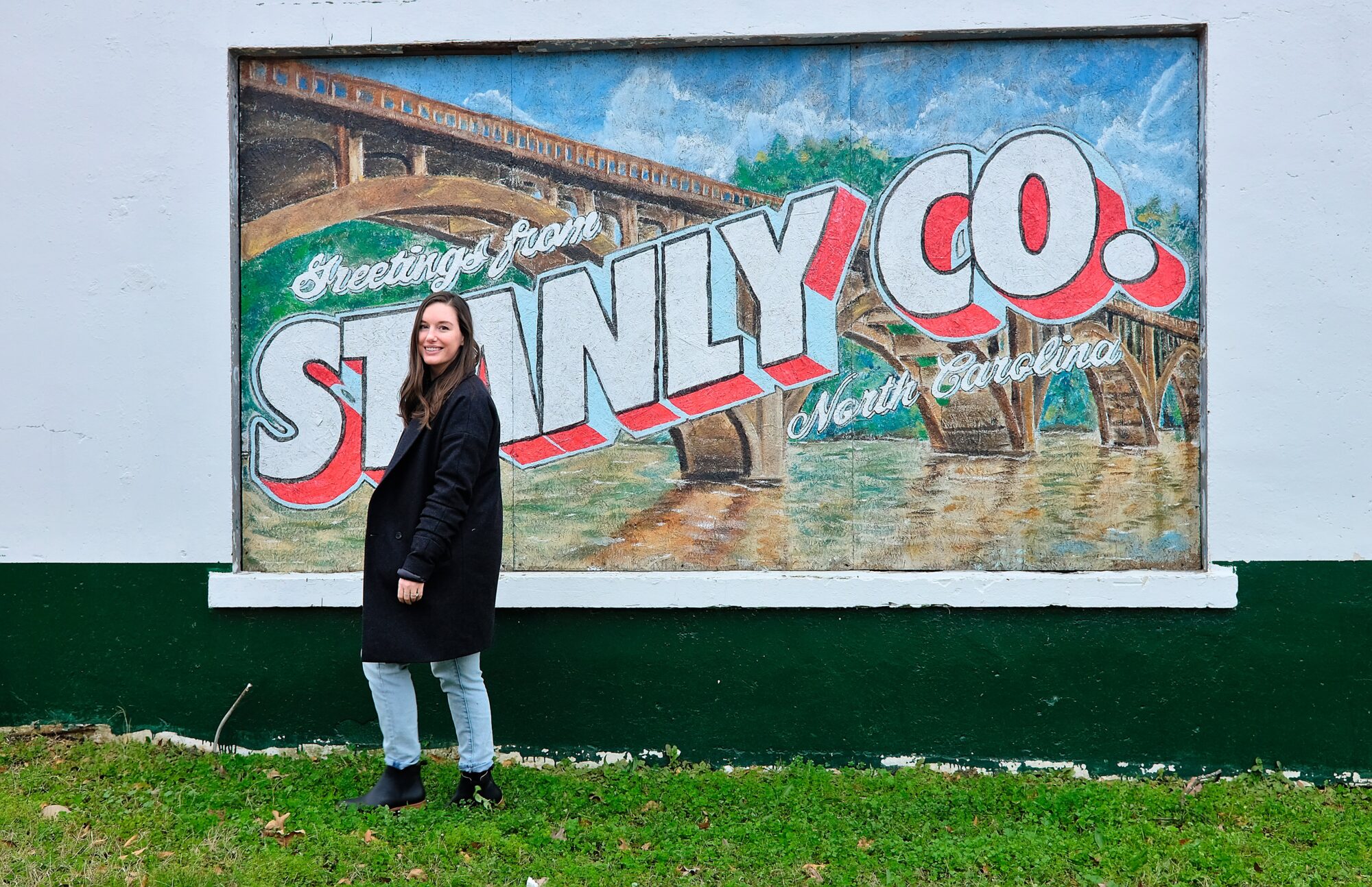 Alyssa walks in front of the Greetings from Stanly County Mural