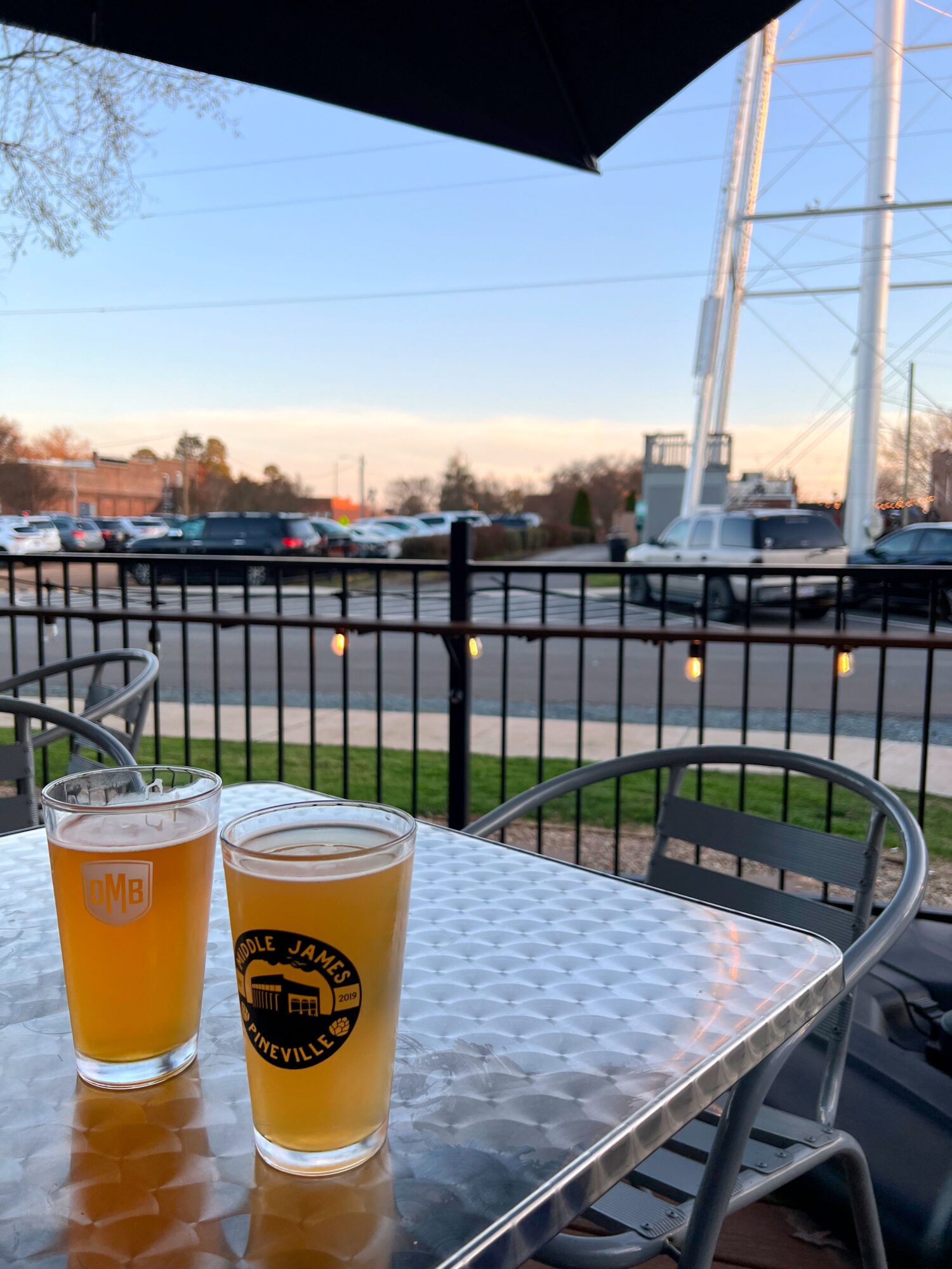 Two beers from Waxhaw Tap House on the patio with the water tower in the background