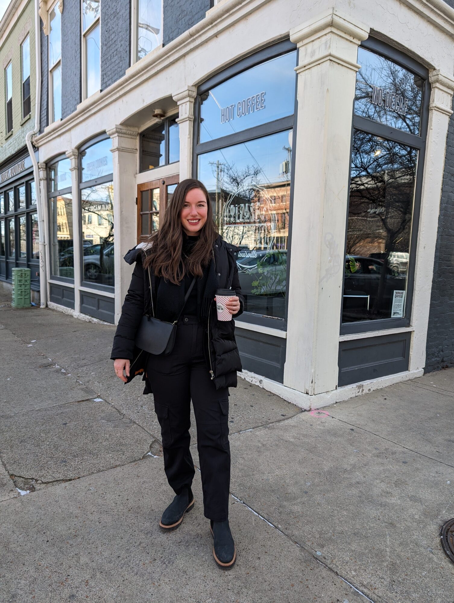 Alyssa stands outside of Please & Thank You in Louisville wearing all-black