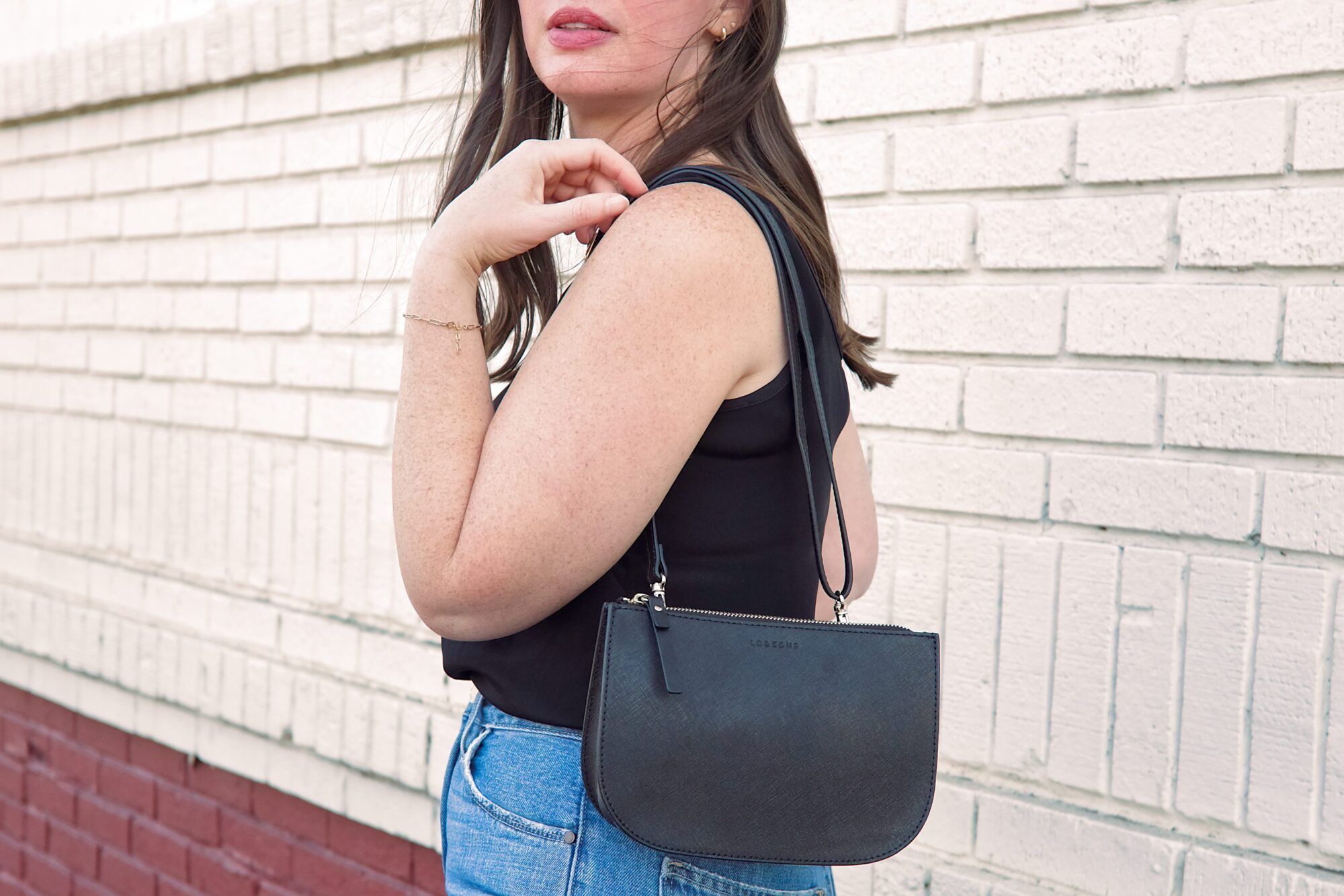 Alyssa carries the Lo & Sons Waverley 2 bag on her shoulder