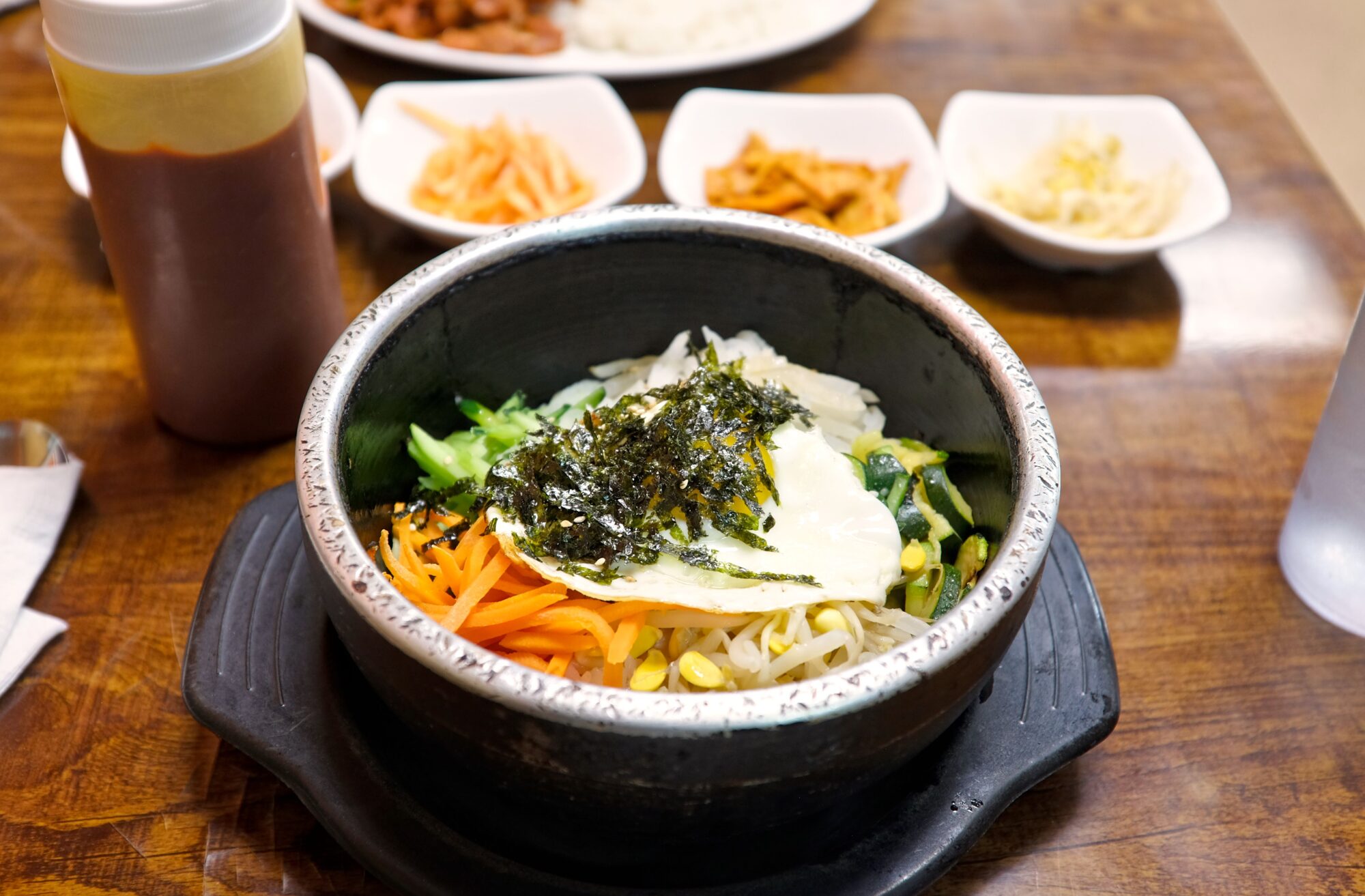 A bowl of bi bim bop on a hot piot with banchan