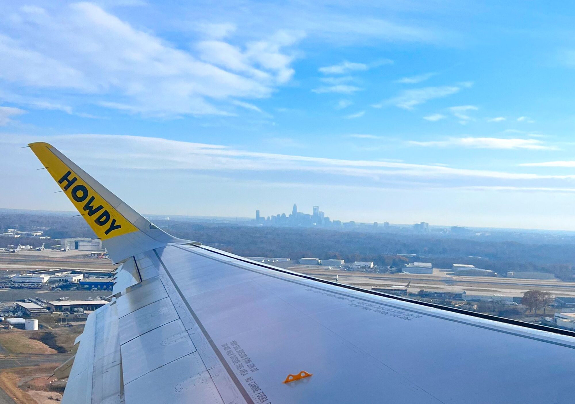 A Spirit plane flies over Charlotte with the skyline in the background