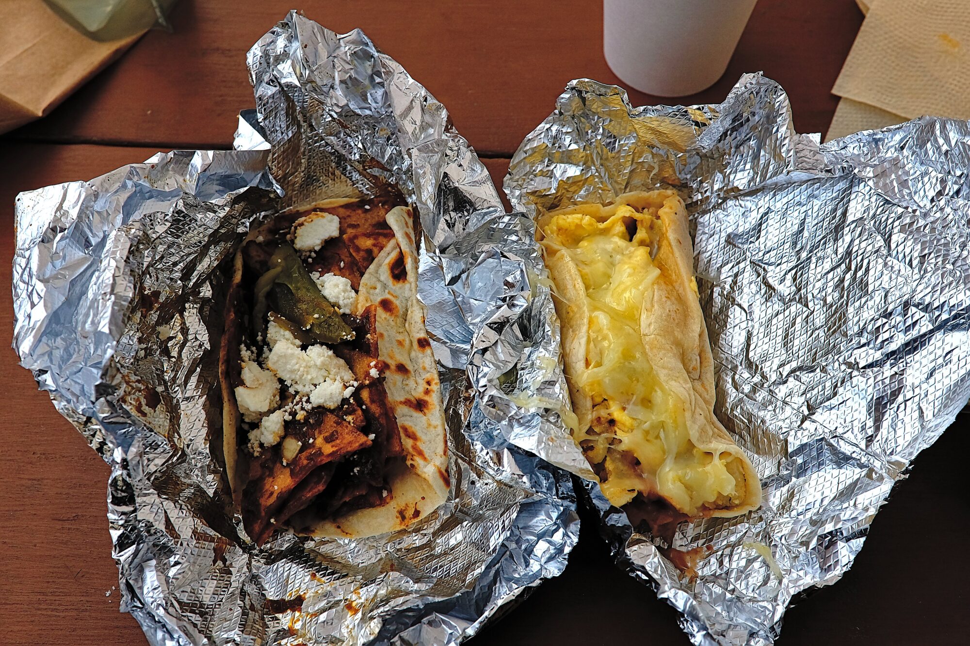 Two breakfast tacos in foil wrappers
