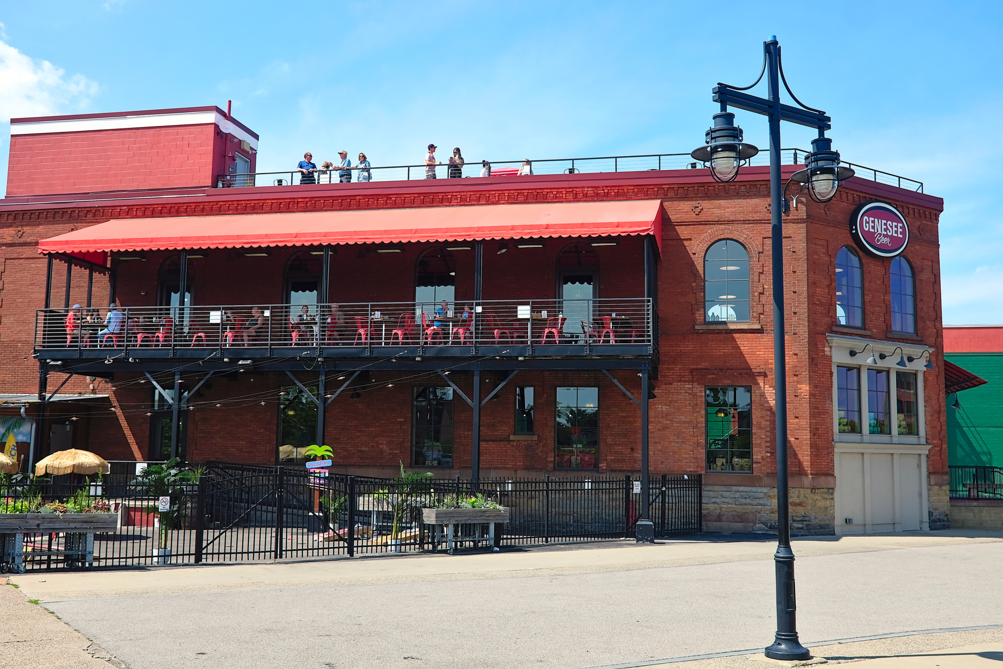 A crowd dining and drinking on the patio at Genesee Brew House