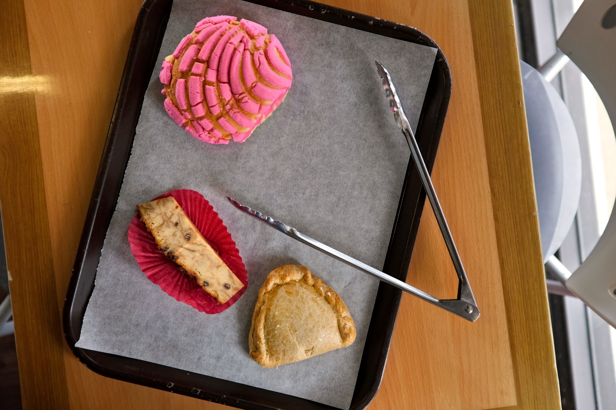 A tray with pastries and tongs