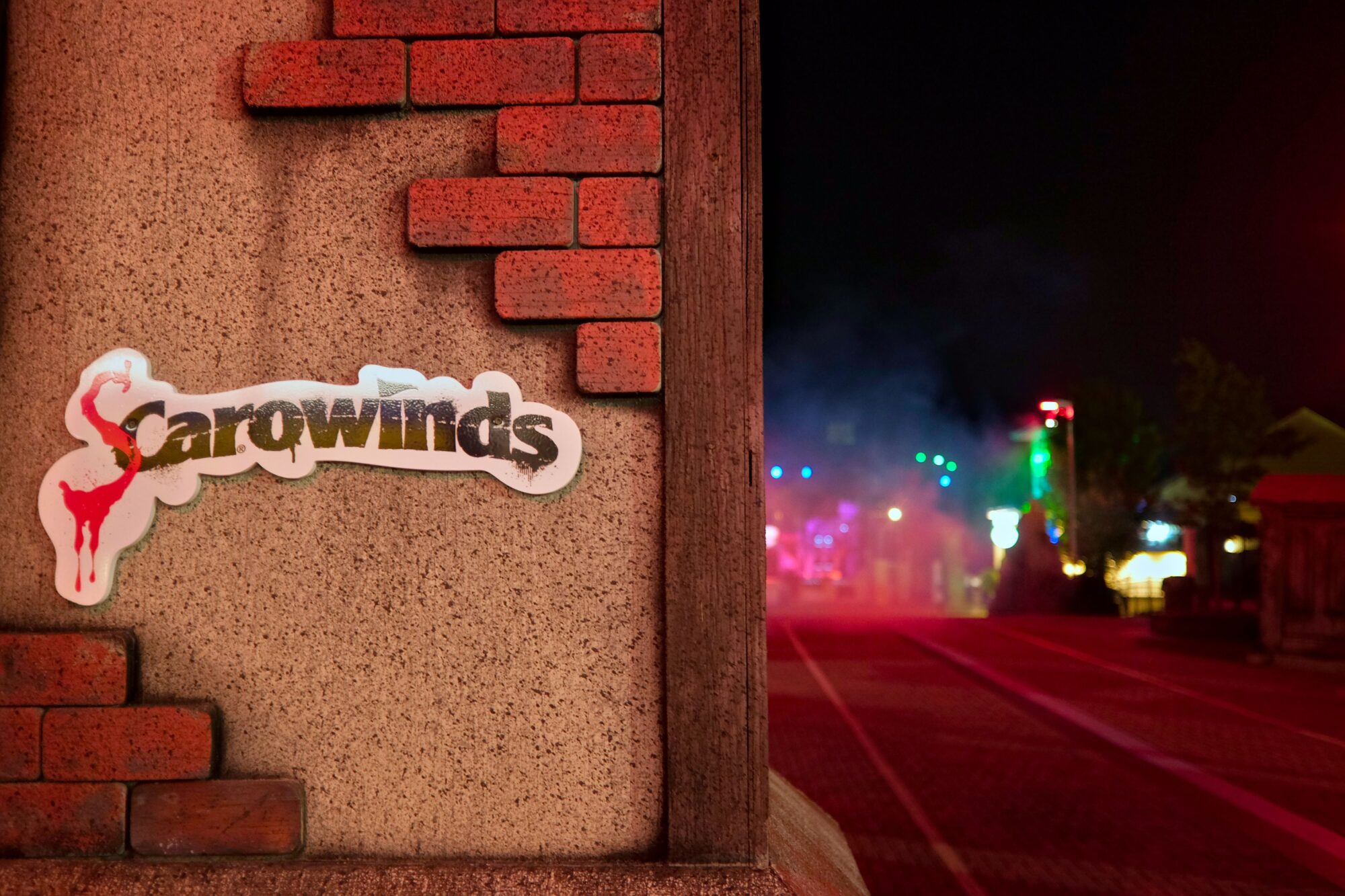 A sign that reads SCarowinds with the park in the hazy distance