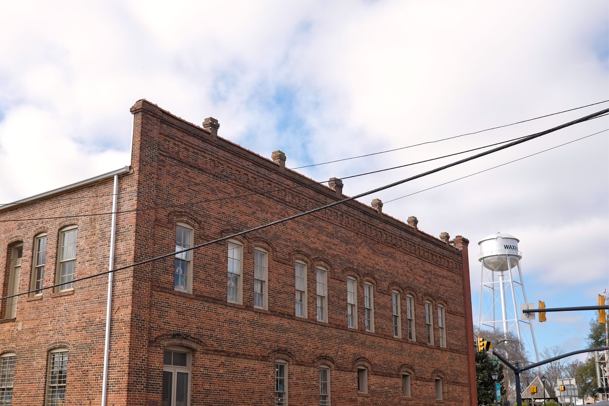 The Waxhaw water tower in the background with a brick building in the foreground