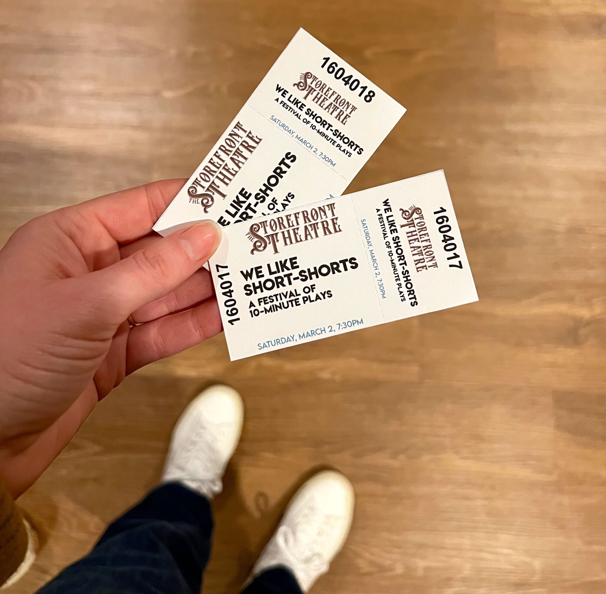 Alyssa holds a pair of tickets for The Storefront Theatre